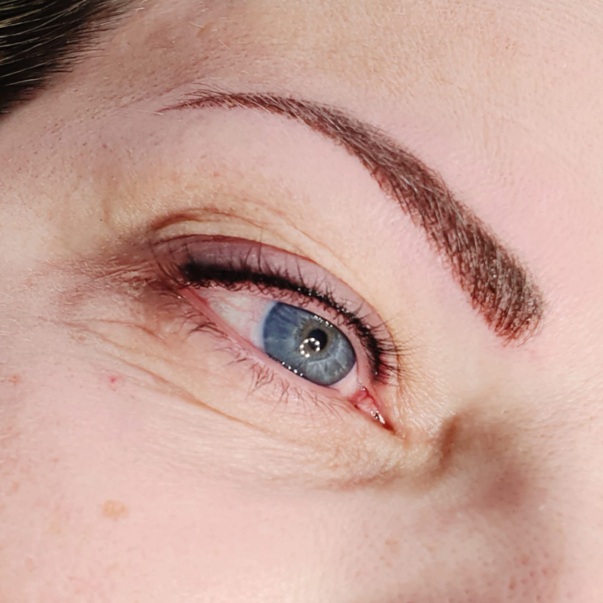 Un primo piano dell'occhio di una donna con un occhio azzurro.