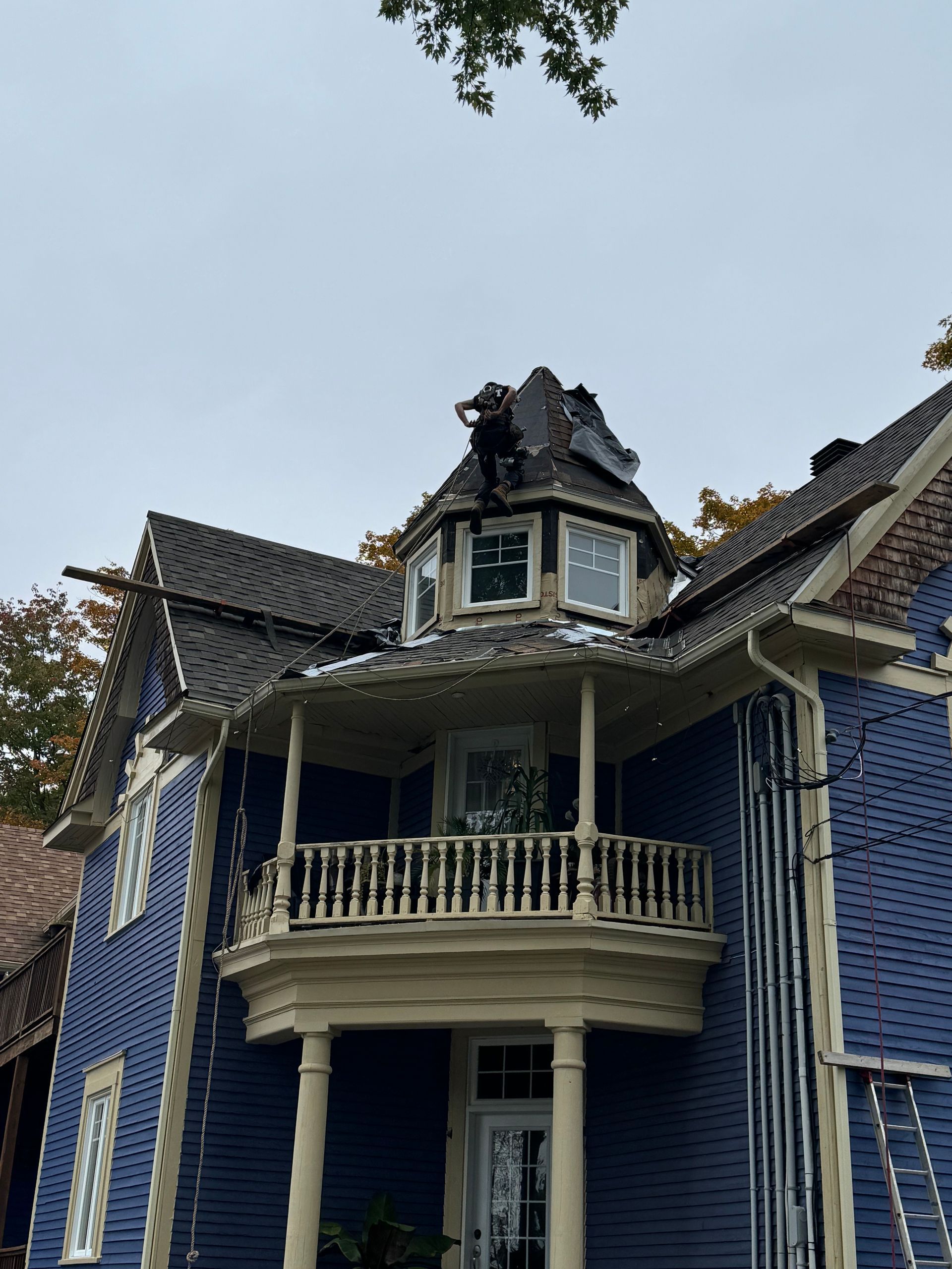 Maison victorienne bleue avec un toit brûlé.