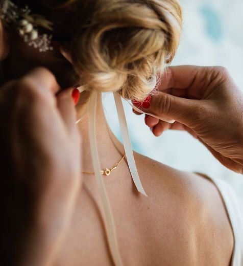 A Woman Is Getting Her Hair Done By A Hairdresser — Elements Hair Artists In Belmont, NSW