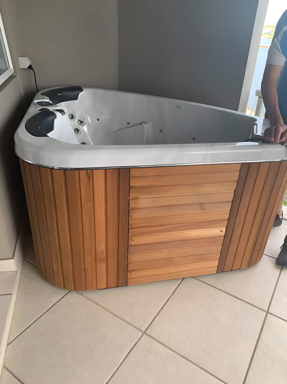 A Man Is Standing Next To A Wooden Hot Tub On A Tiled Floor — Pool Zone in Port Macquarie, NSW