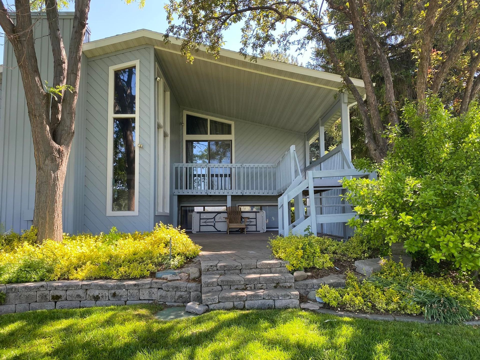Light blue house with a covered porch and stone walkway.