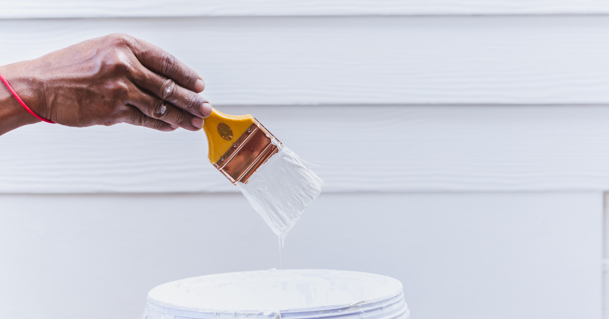 Bathroom interior with white bathtub and shower surround, light beige walls, two recessed lights, and unfinished flooring.