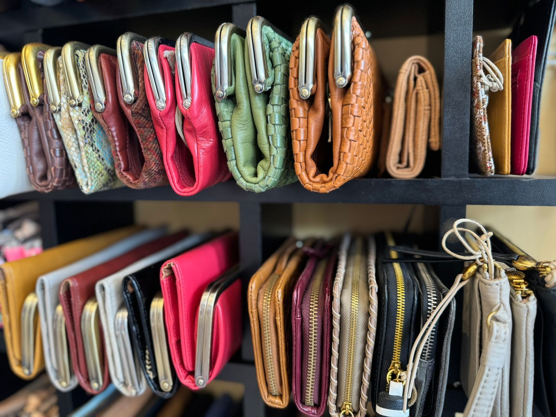 A bunch of wallets are lined up on a shelf