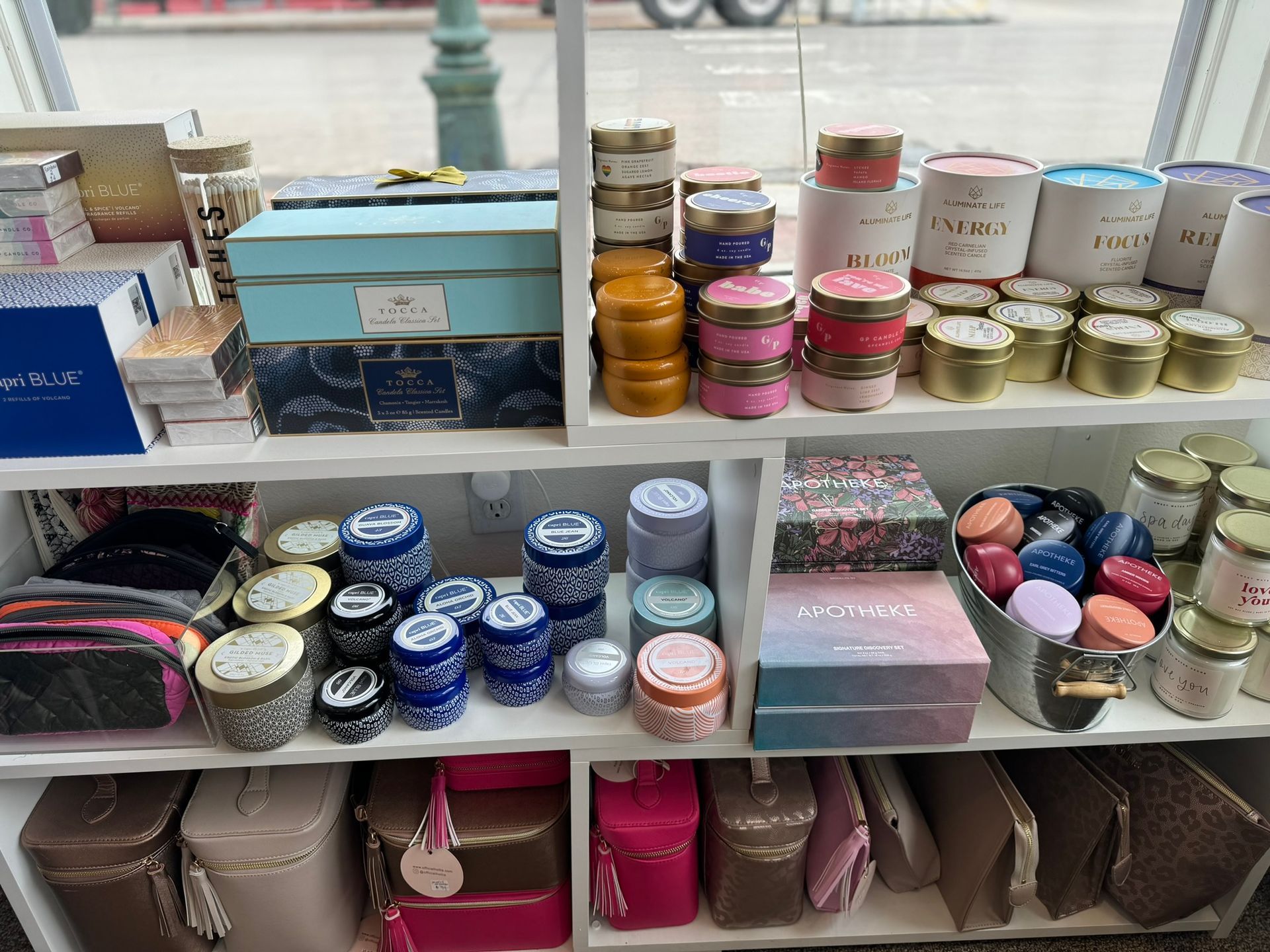 A shelf filled with lots of candles and boxes.