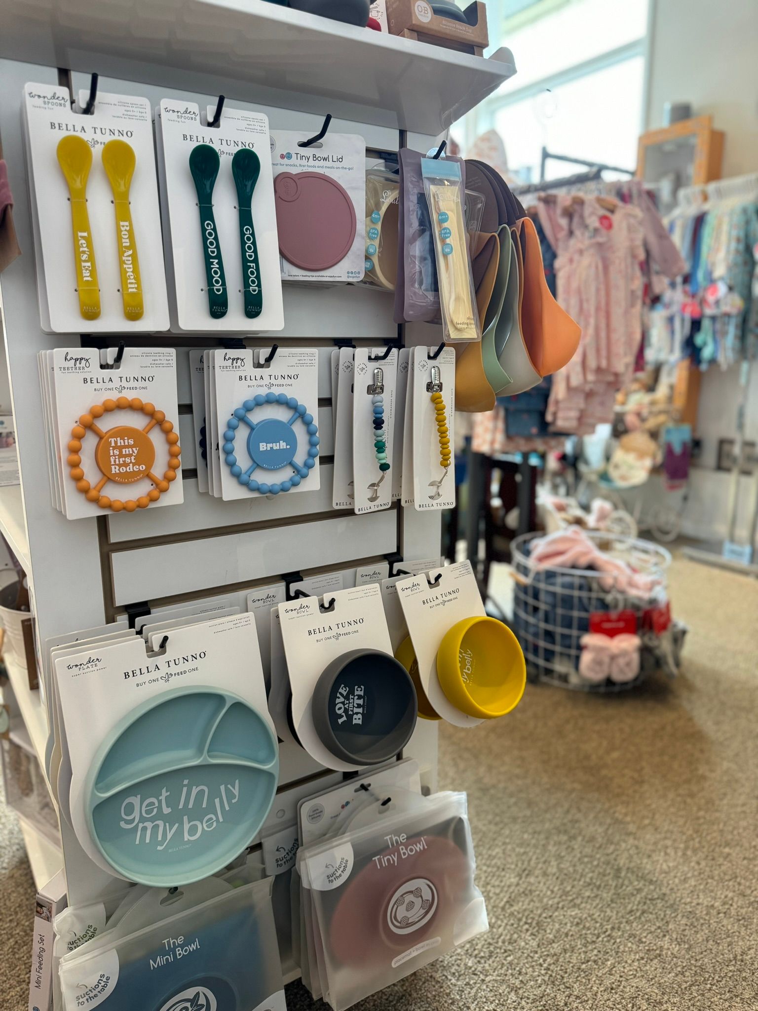 A display of baby plates , bowls , and spoons in a store.