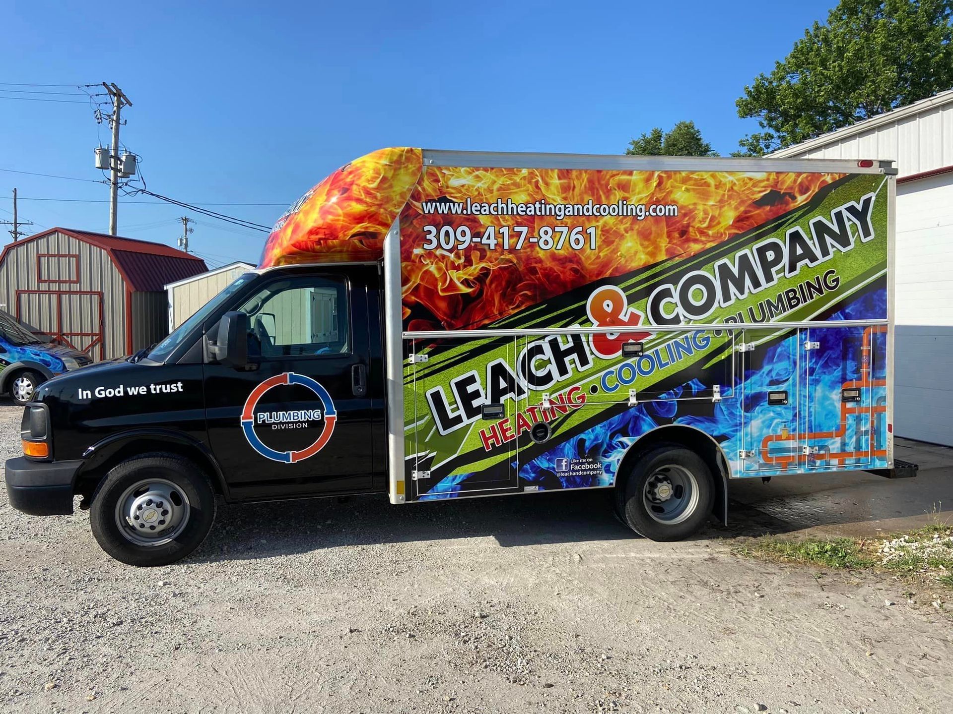 A leak & company truck is parked in a gravel lot.