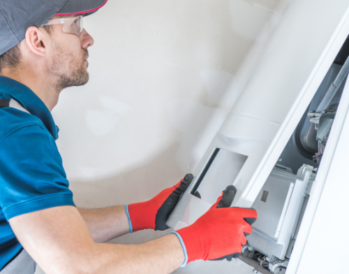 A man wearing red gloves is working on a machine.