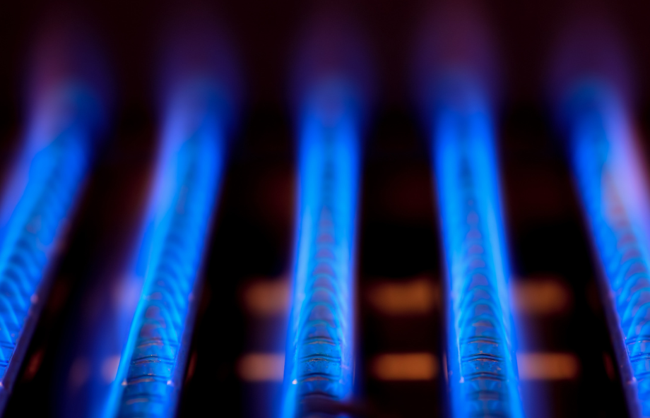 A close up of a gas burner with blue flames coming out of it.
