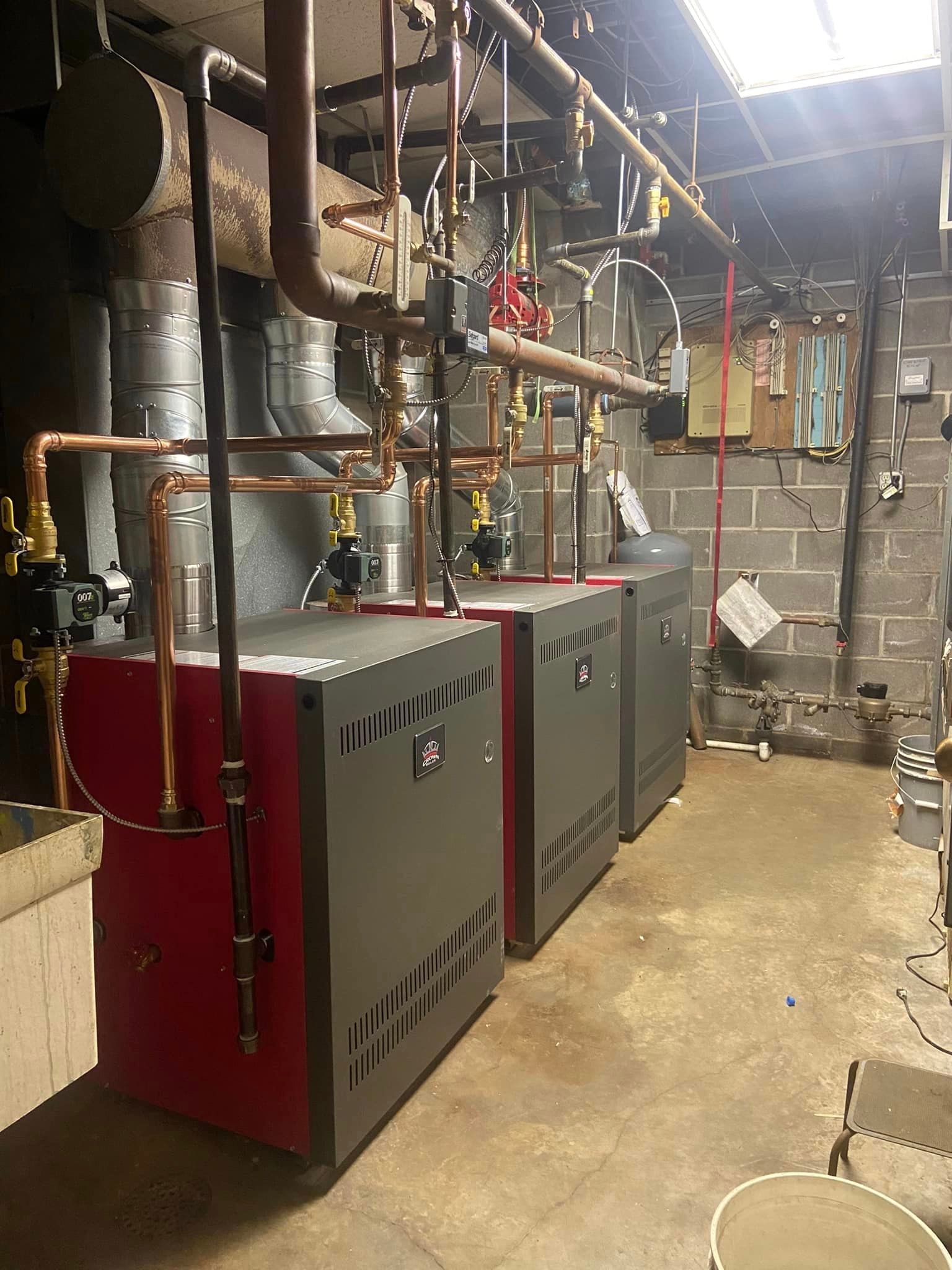 A room with a lot of pipes and boilers in it.