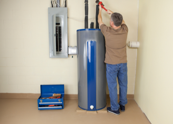 A man is fixing a water heater with a wrench.
