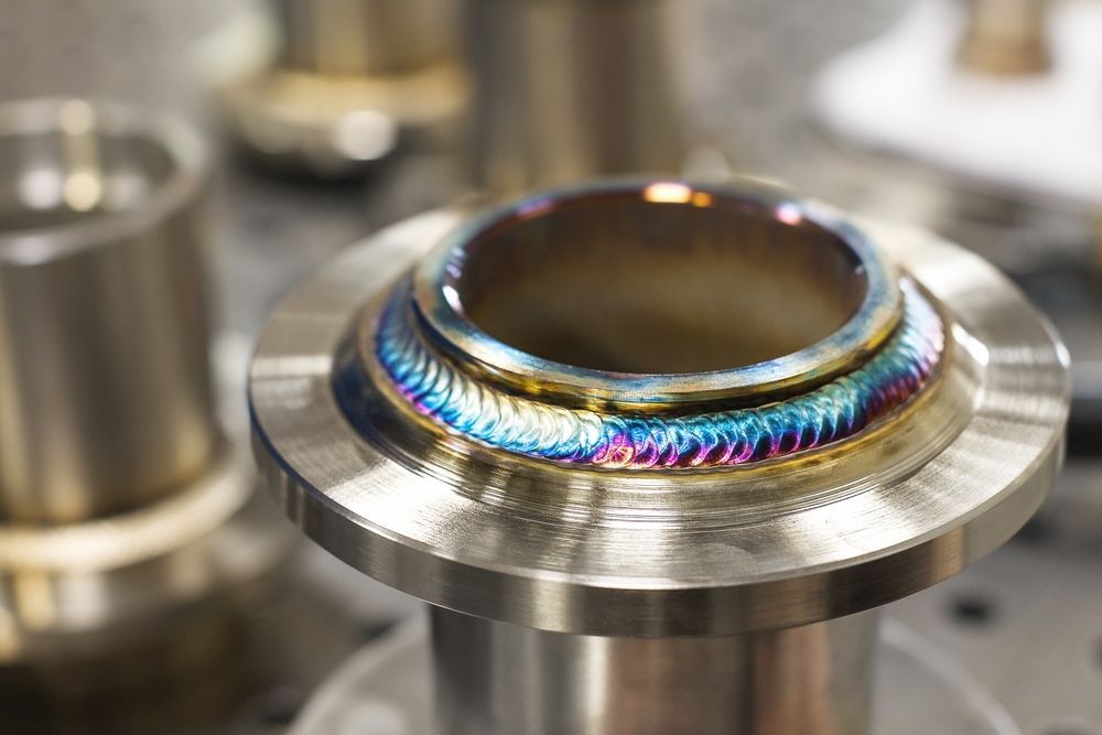 A close up of a metal object with a rainbow colored weld.