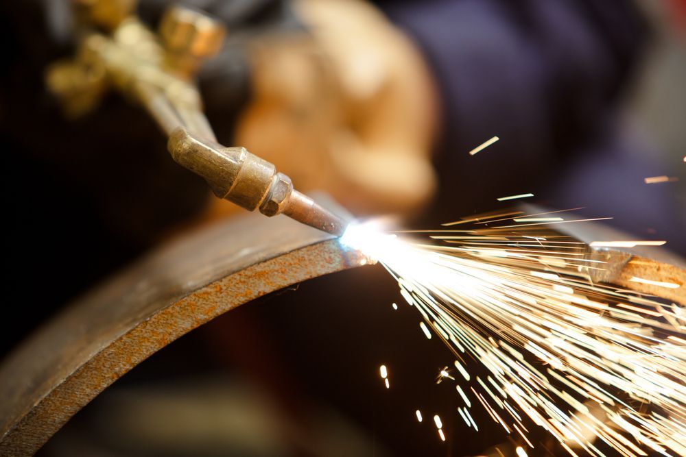A person is cutting a piece of metal with a torch.