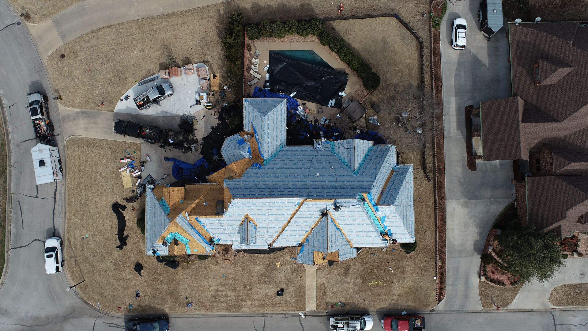 An aerial view of a house under construction in a residential area.