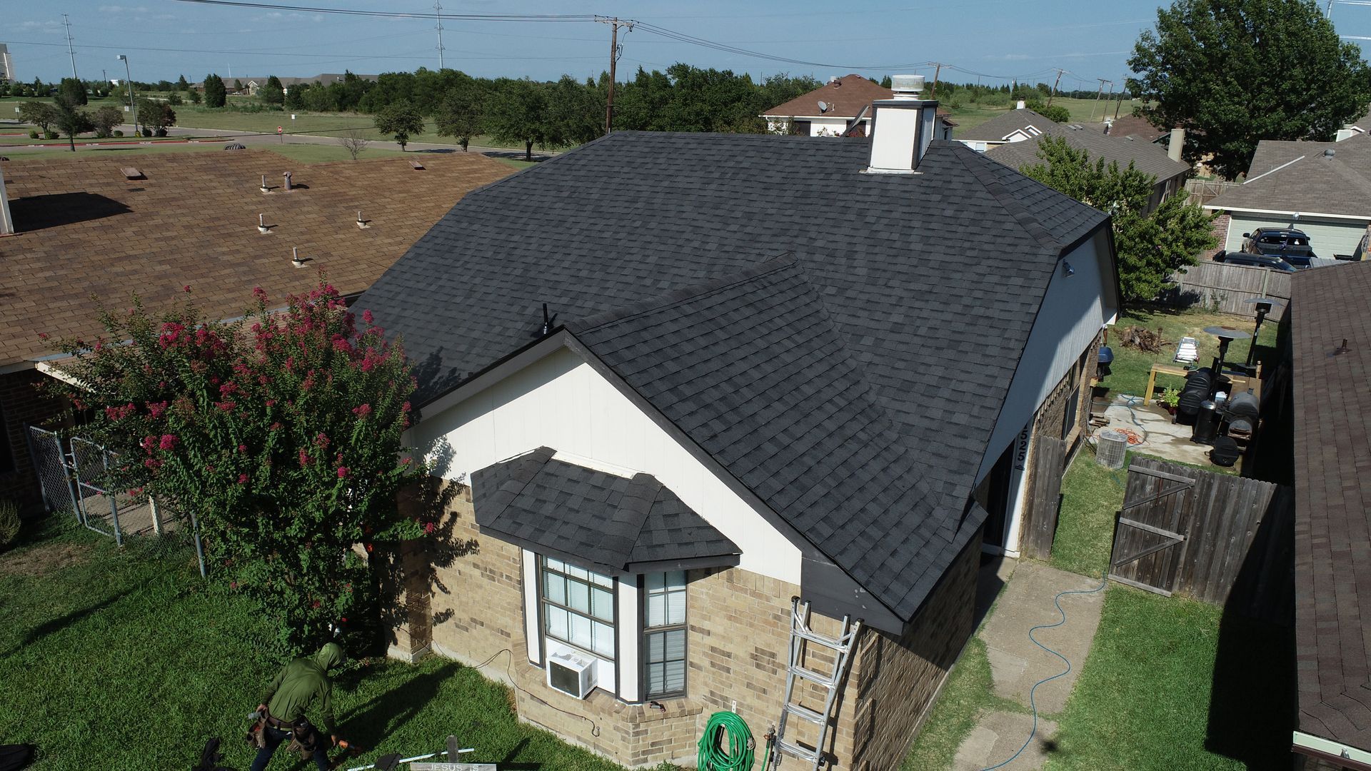 An aerial view of a house with a new roof. An aerial view of a house with a new roof.