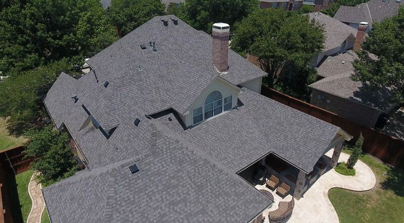 An aerial view of a large house with a gray roof.