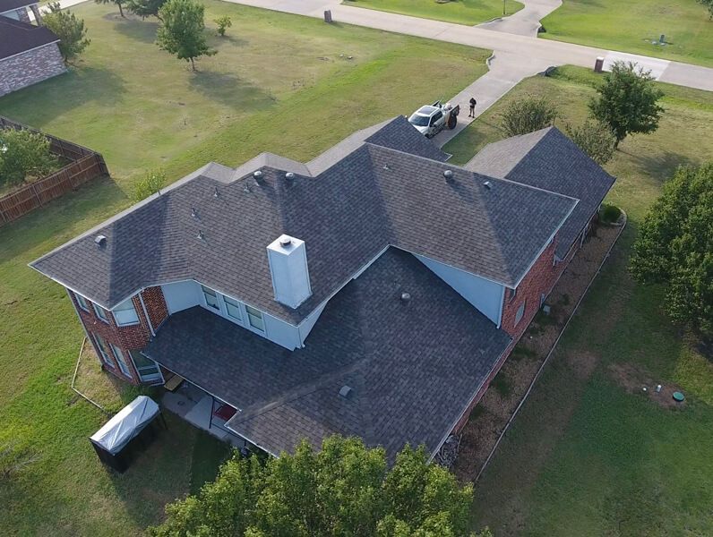 An aerial view of a house with a roof and a chimney.