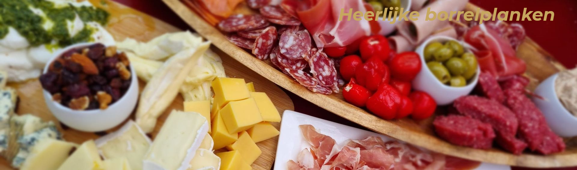 Een kleurrijke selectie charcuterie en kaasplanken met vleeswaren, kazen, olijven, noten en gedroogd fruit.