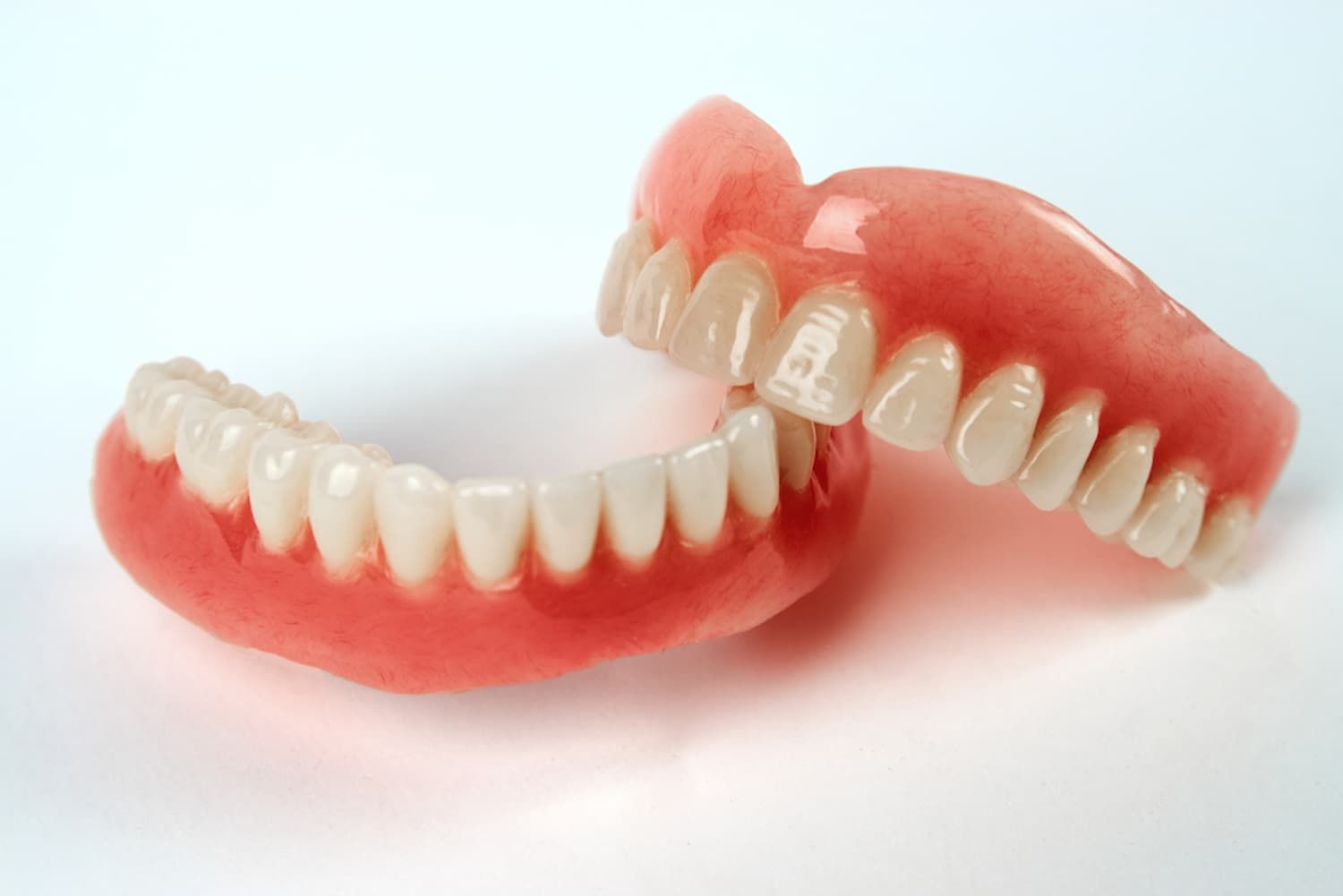 A Close up Of a Pair of Dentures on A White Surface — Cane to Coast Dentures in Sarina, QLD