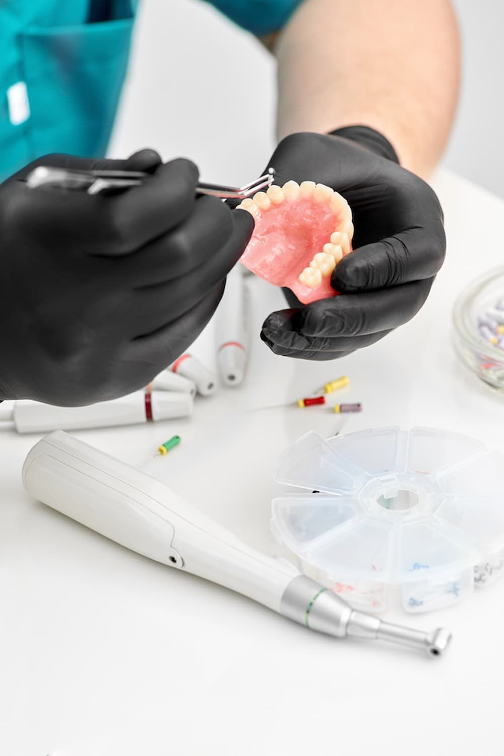 A Dentist Is Working on A Denture with A Pair of Scissors — Cane to Coast Dentures in Proserpine, QLD