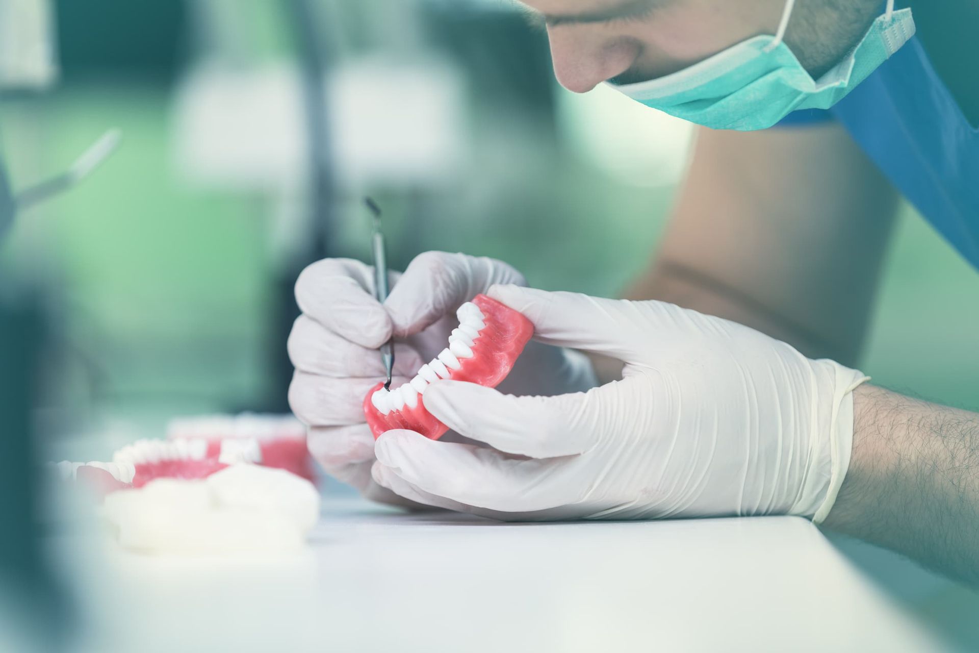 A Dentist Is Working on A Model of A Person 's Teeth — Cane to Coast Dentures in Sarina, QLD