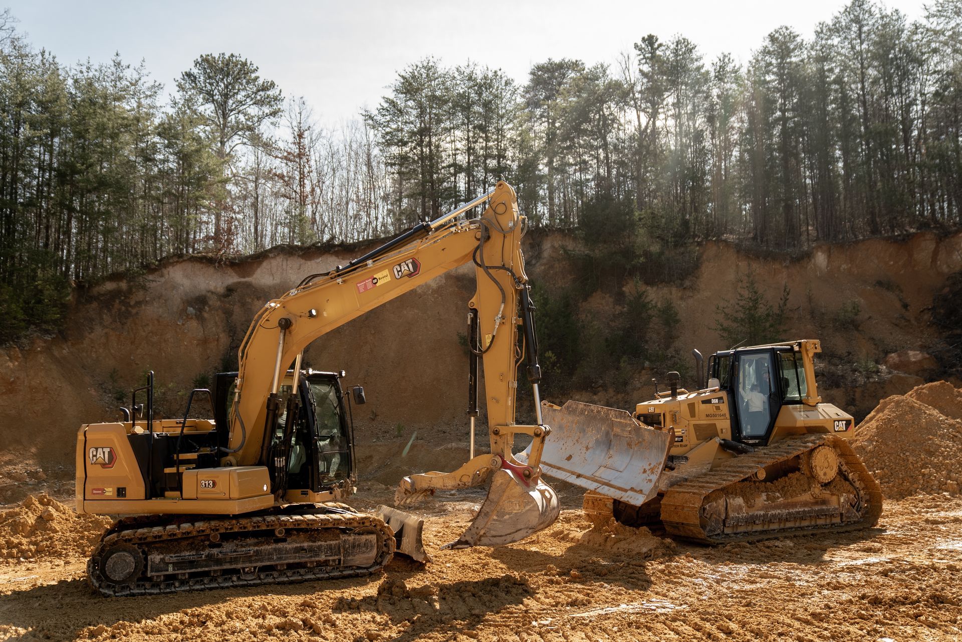 Yellow Caterpillar excavator and bulldozer working at a construction site.