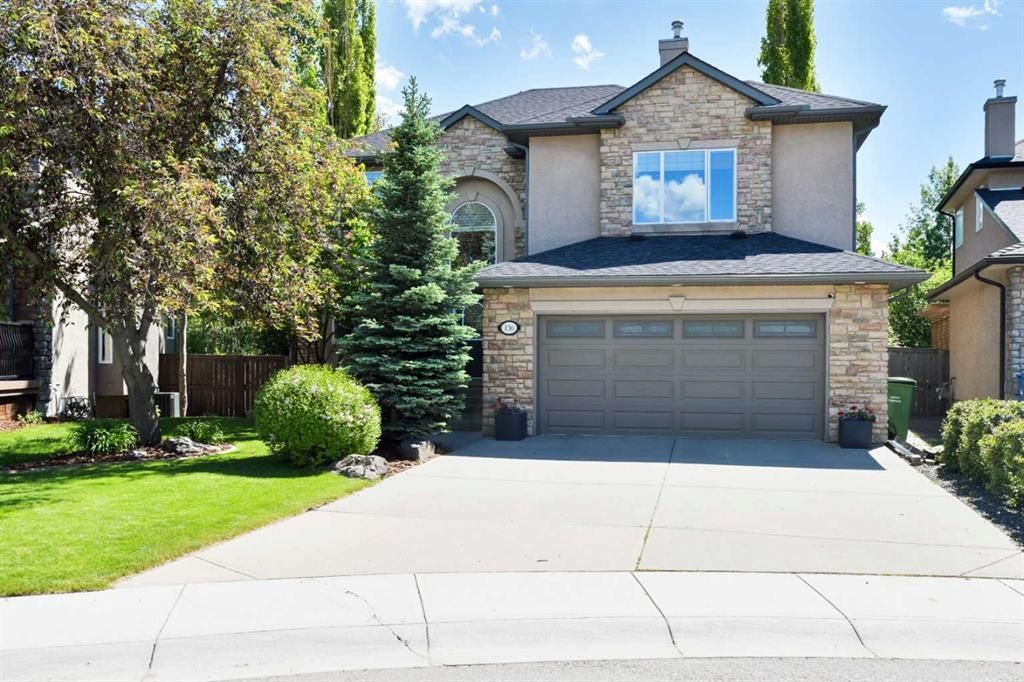 Two-story brick suburban house with a double garage, driveway, and manicured front yard