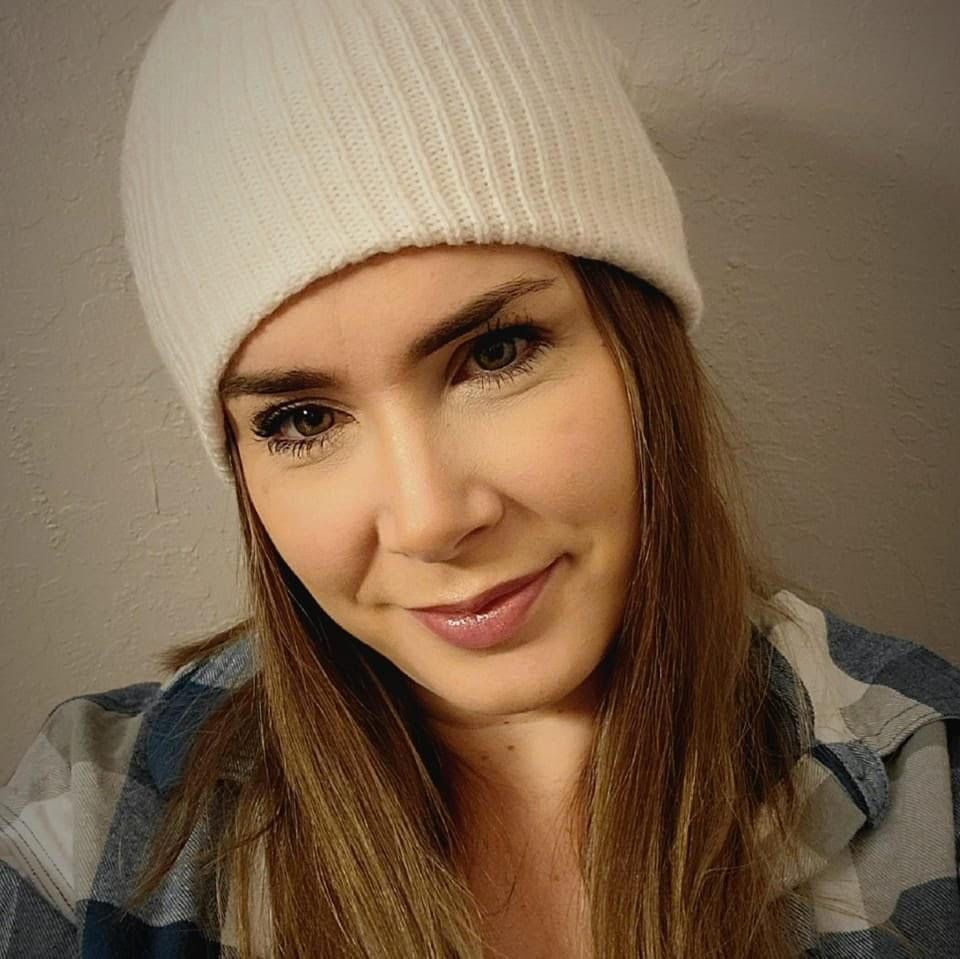 A woman wearing a white beanie and a plaid shirt