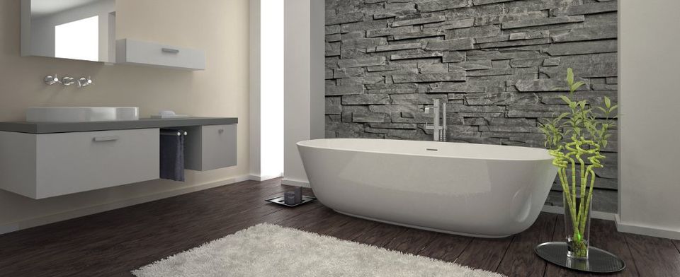 Free standing bath in front of slate wall