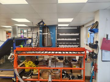 Glass shop internal view, hot melt machine, clamp bench and industrial glass washer