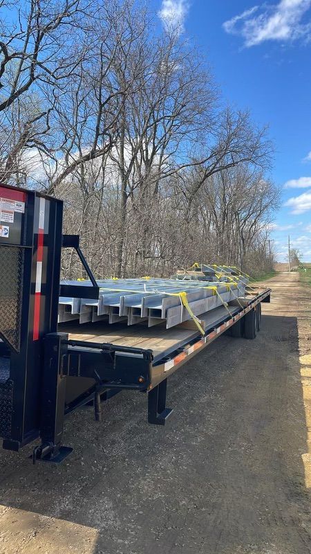 A semi truck is carrying a load of aluminum sheets on a trailer.