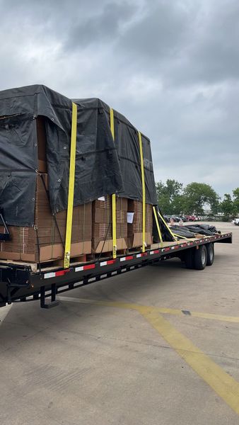 A semi truck is carrying a large load of boxes on a trailer.