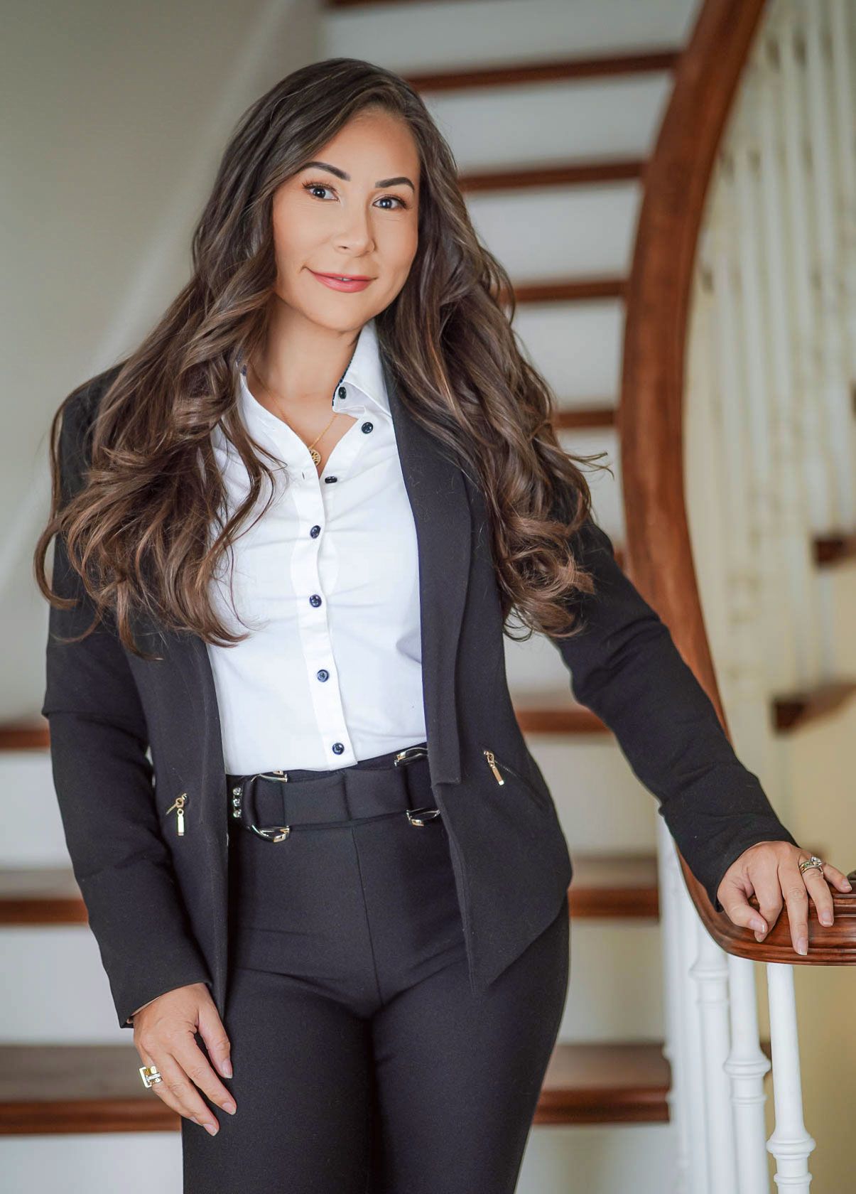 A woman in a suit is standing on a set of stairs.