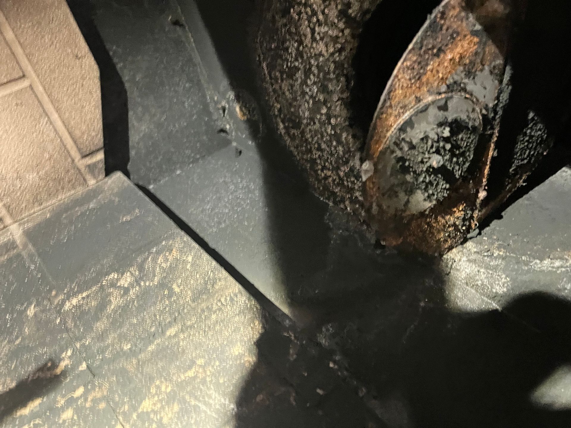 Inside of a metal snowblower, showing blades and snow residue.