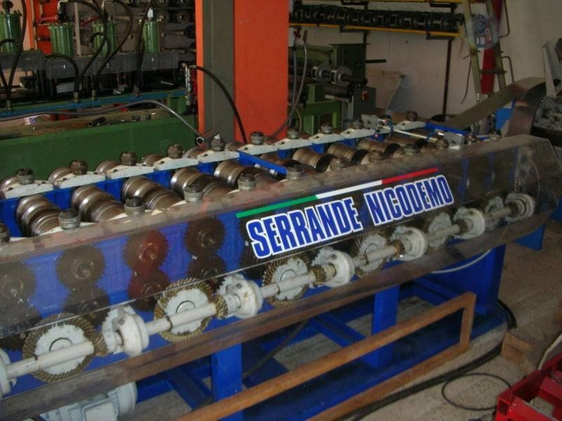 Una macchina per la formatura dei metalli con rulli, etichettata 