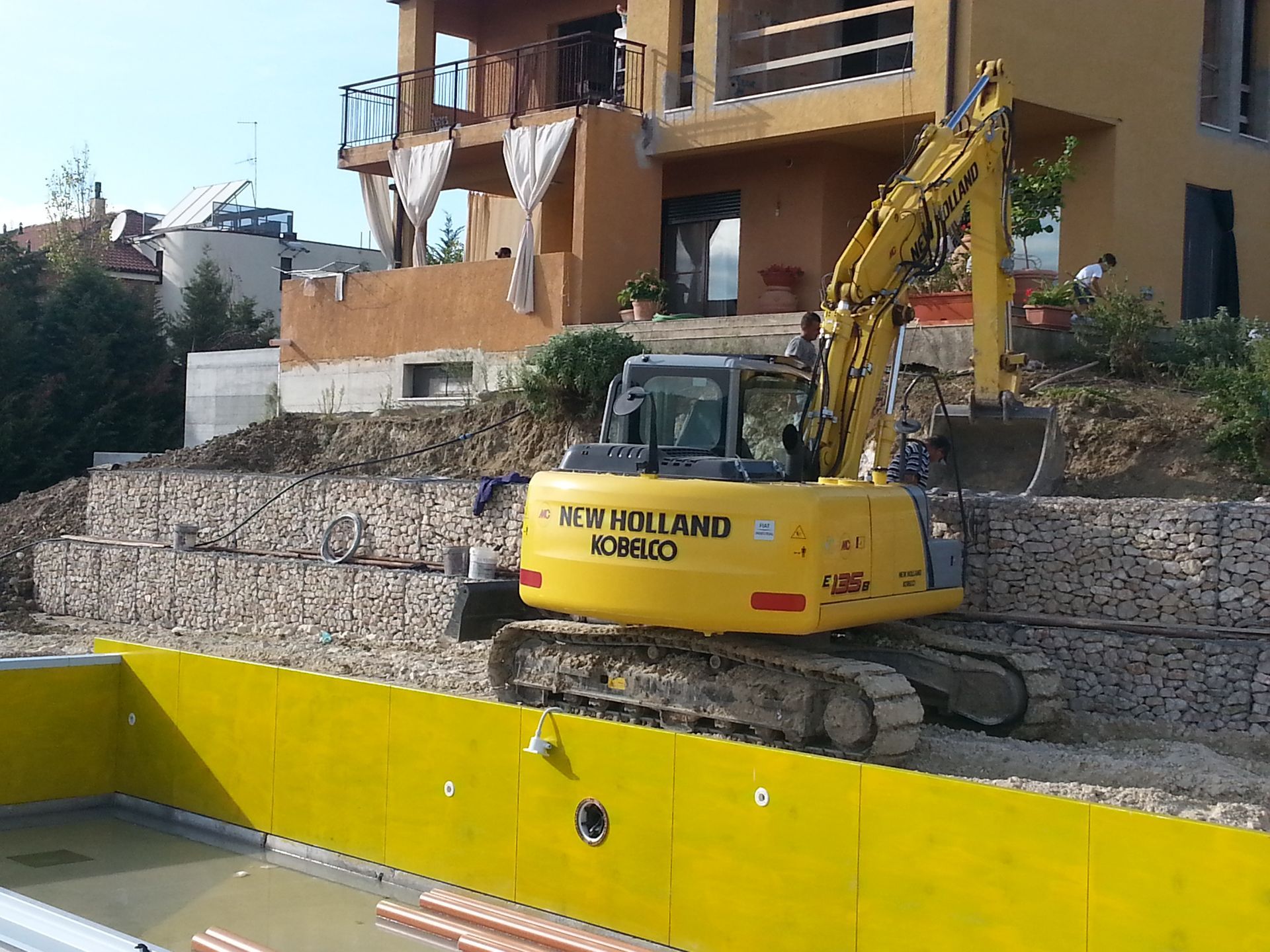 Un escavatore giallo con la scritta New Holland sopra