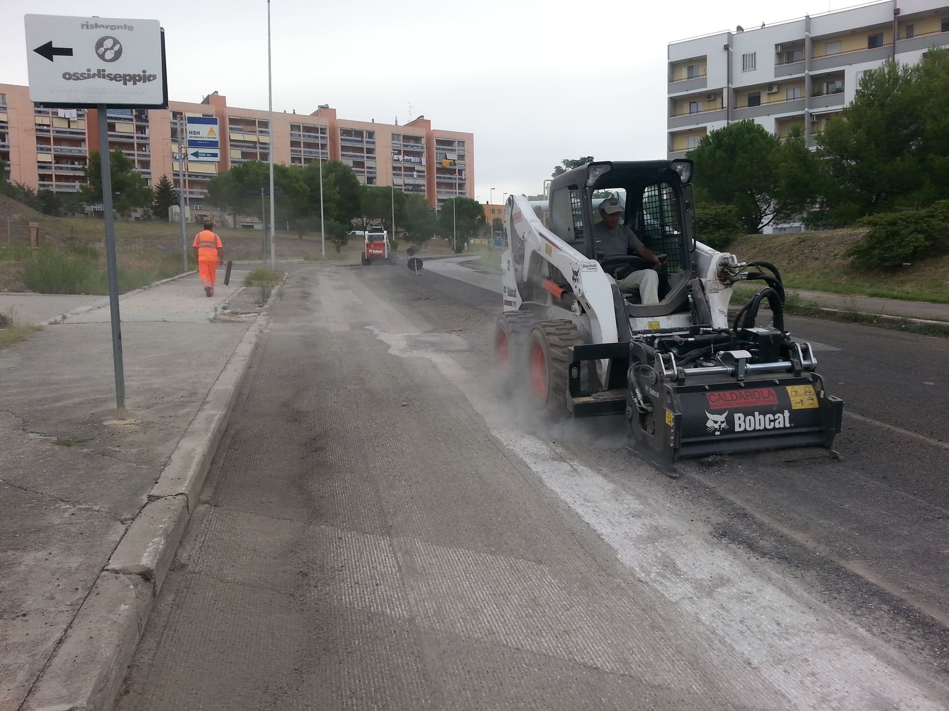 Un trattore Bobcat sta guidando lungo una strada
