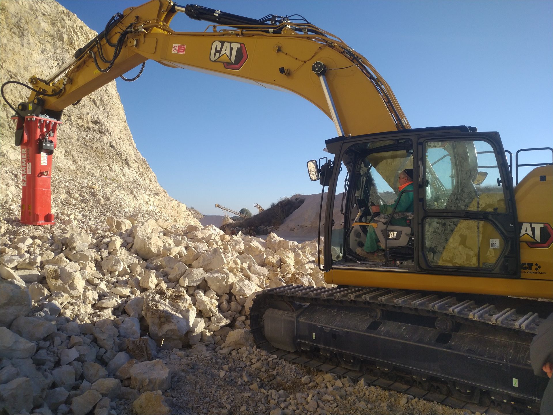 Un escavatore a gatto sta lavorando su un mucchio di rocce