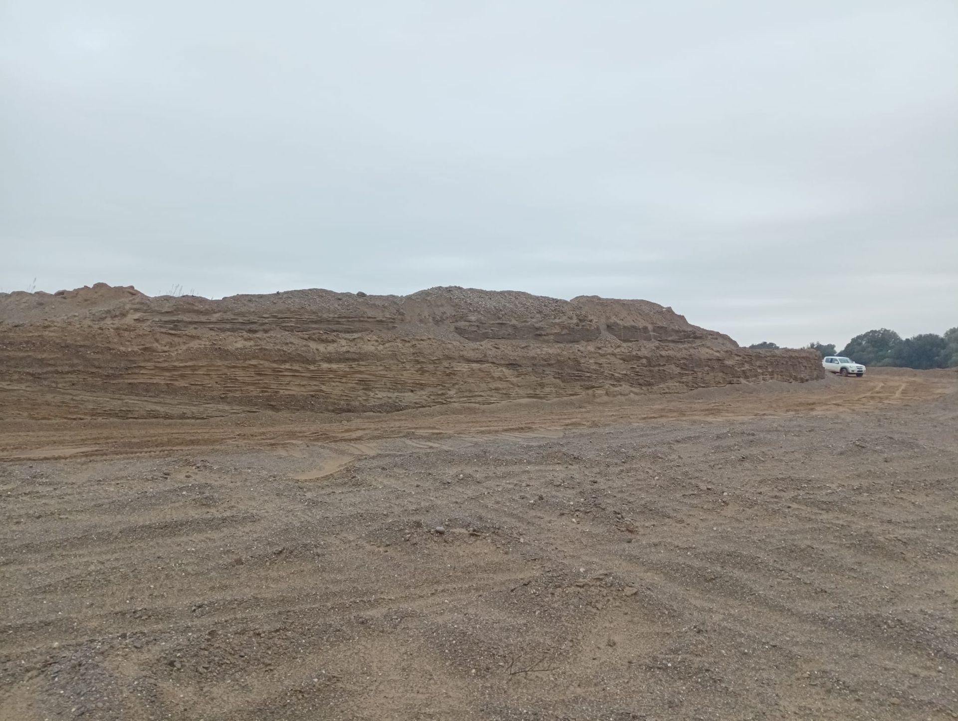 Un grande mucchio di terra si trova in mezzo a un campo di terra.