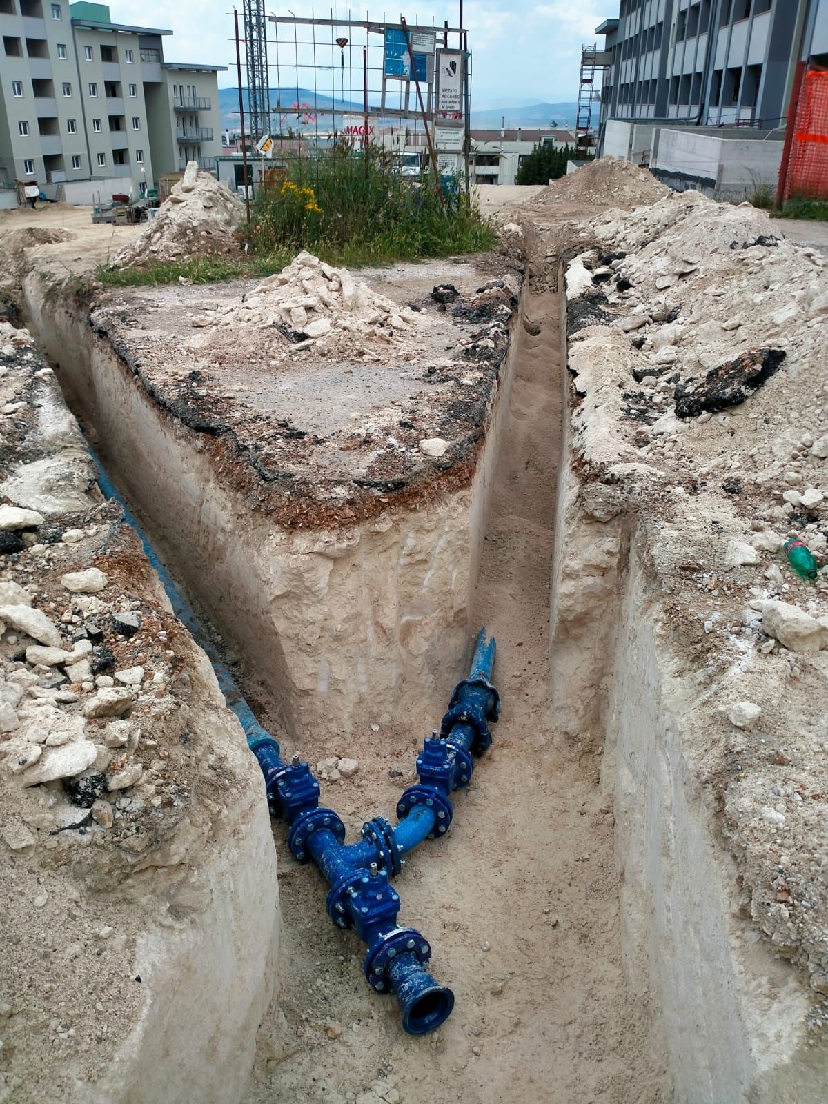 Un tubo blu viene installato in una trincea.