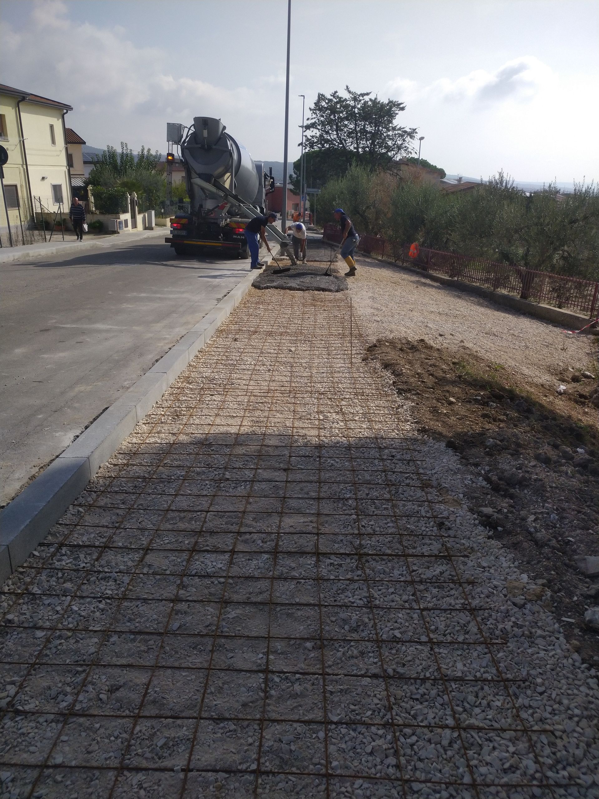 Una betoniera viene utilizzata per mescolare il cemento su un marciapiede