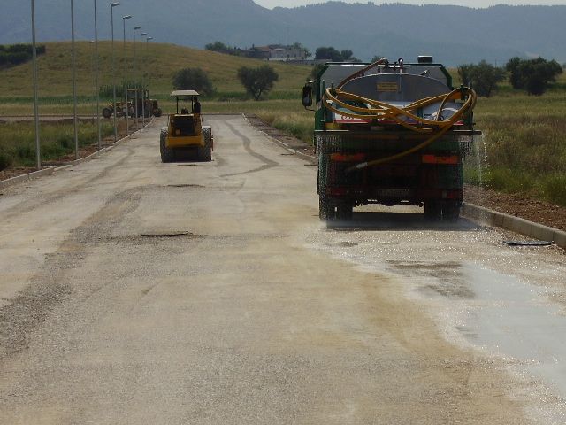 Un camion con un tubo flessibile attaccato sul retro sta guidando lungo una strada