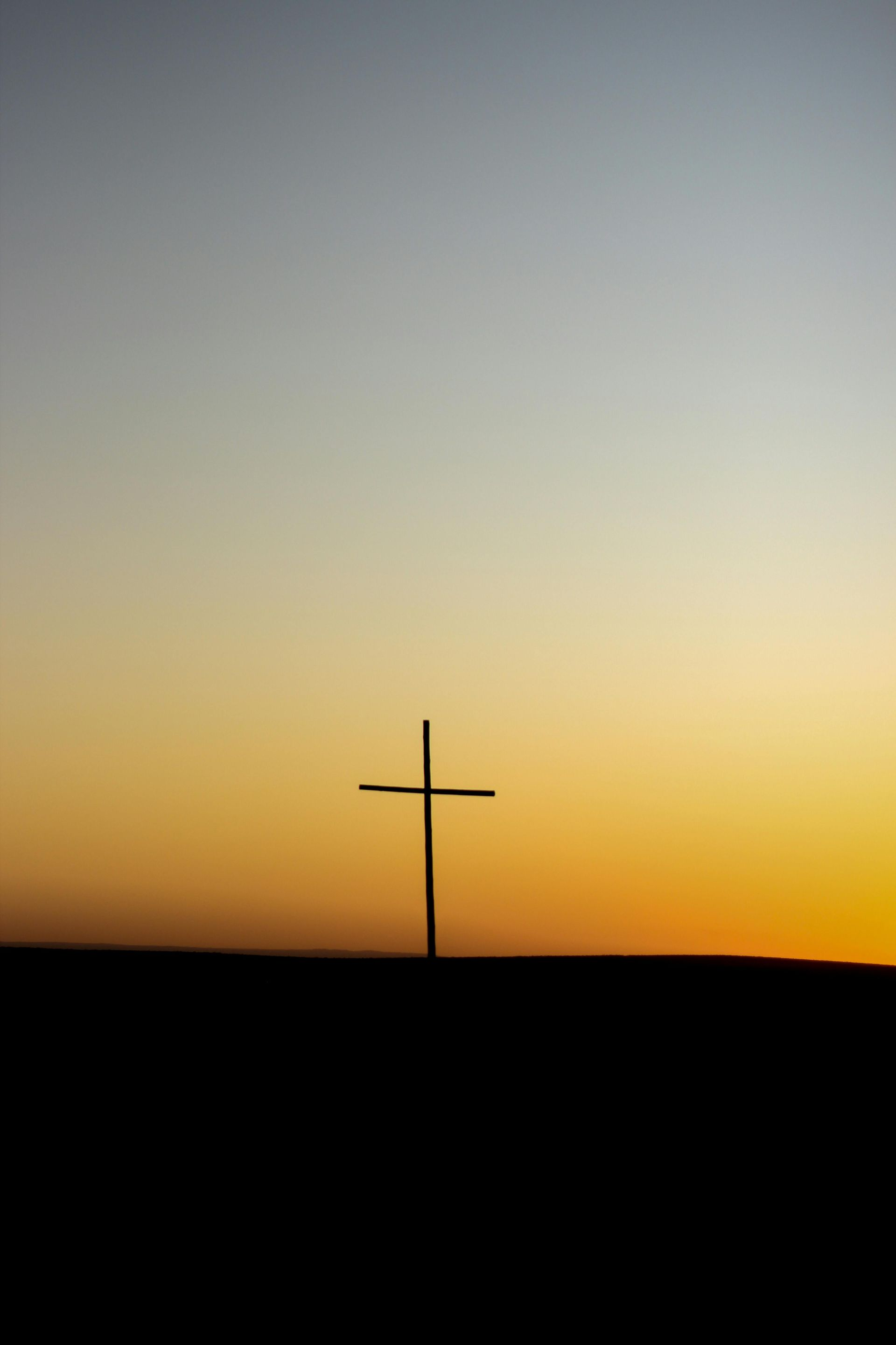 Cross silhouetted against a glowing sunset sky, symbolizing Easter hope and resurrection in Texas.