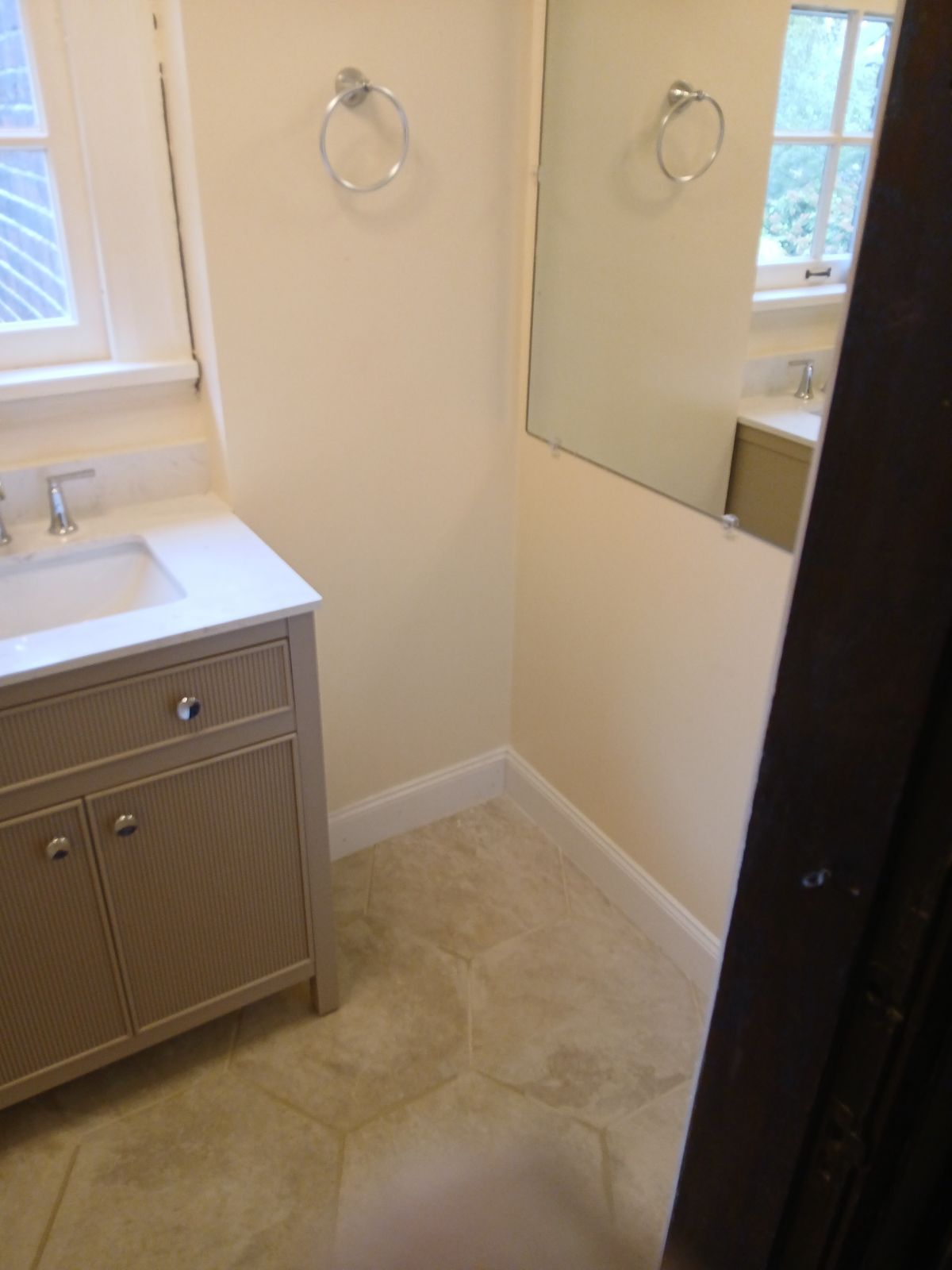A bathroom with a sink a mirror and a window