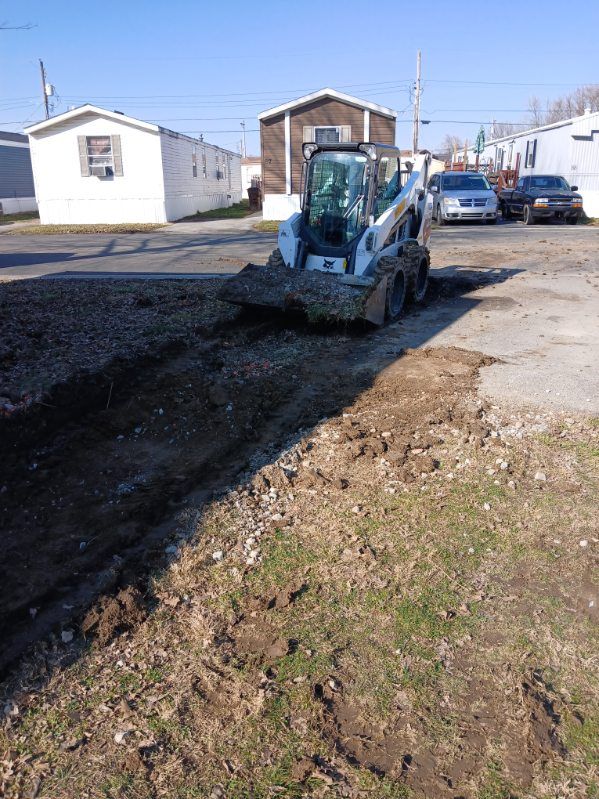 A bobcat is digging a hole in the ground.