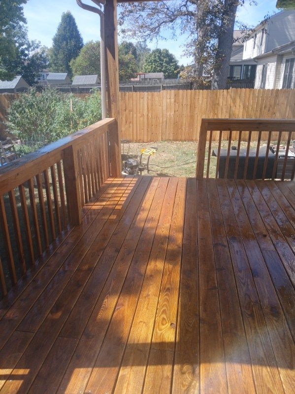 A wooden deck with a fence in the background