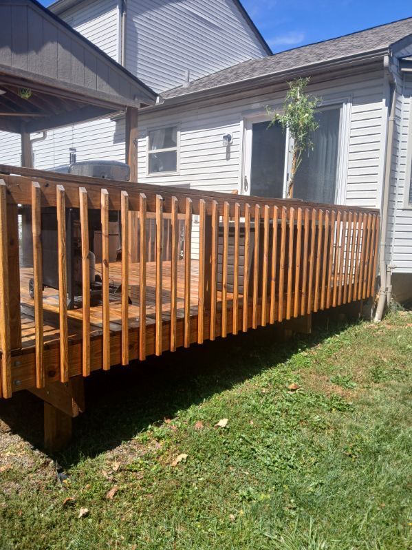 A wooden deck is sitting in front of a house.