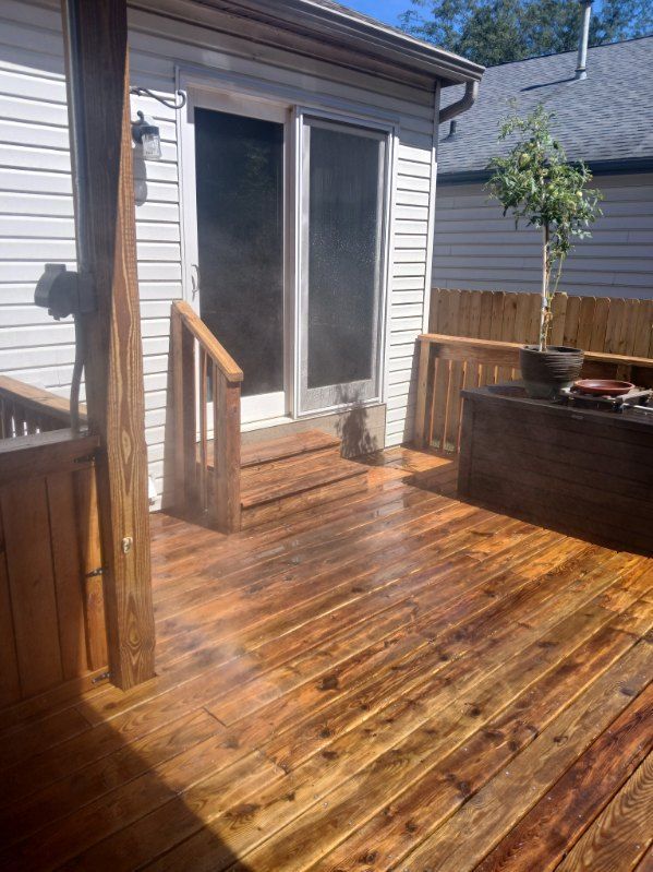 A wooden deck in front of a house with a sliding glass door.