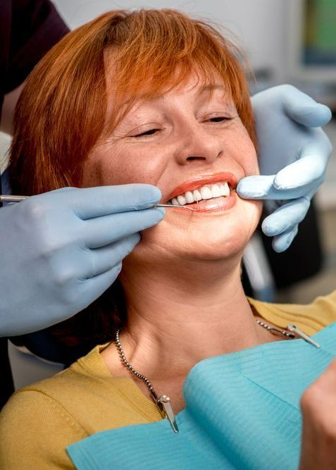 A Woman is Getting Her Teeth Examined by a Dentist — Graham Johnson Dental Surgery In Beresfield, NSW