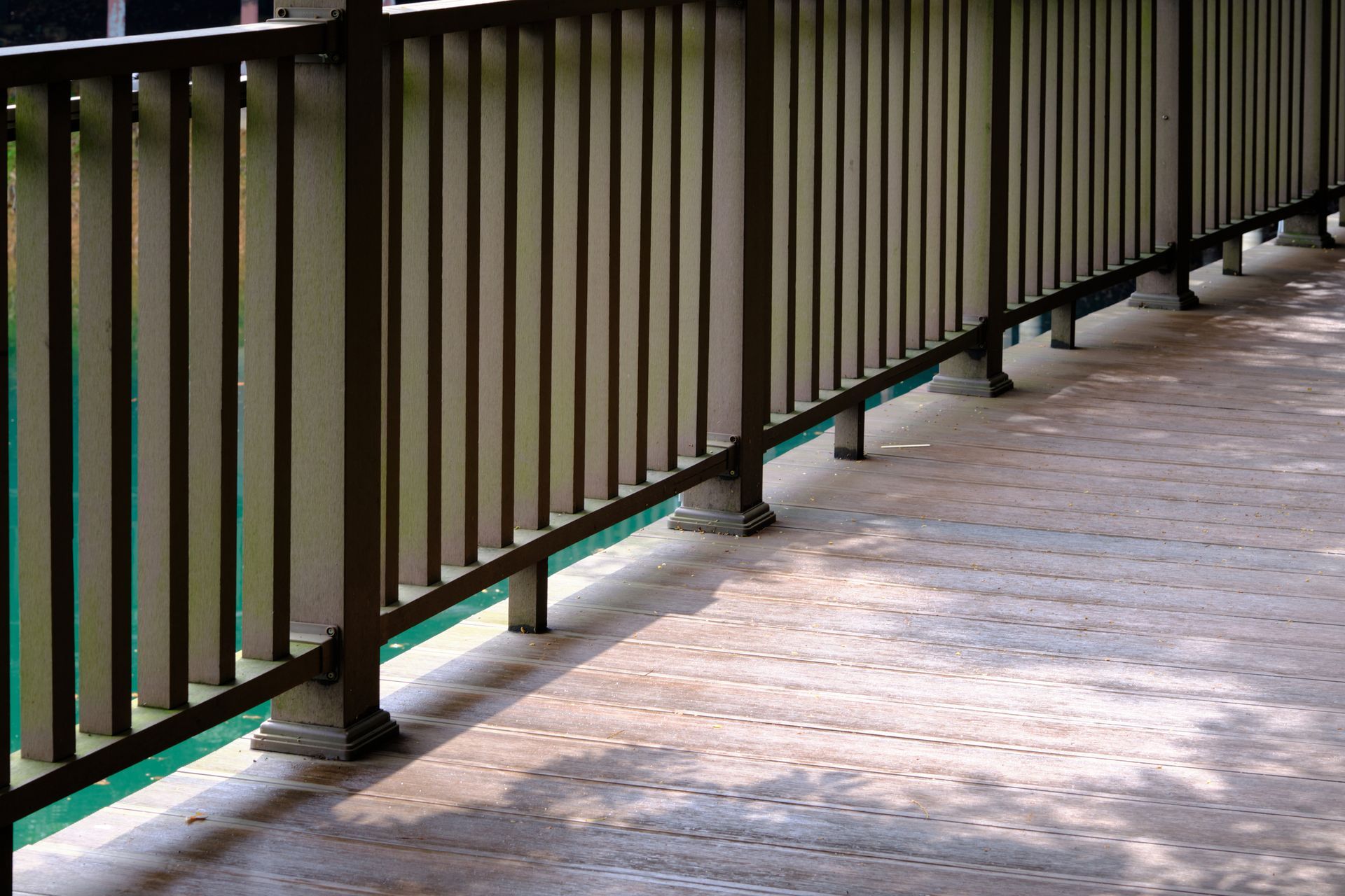Brown metal railing on a stone walkway.