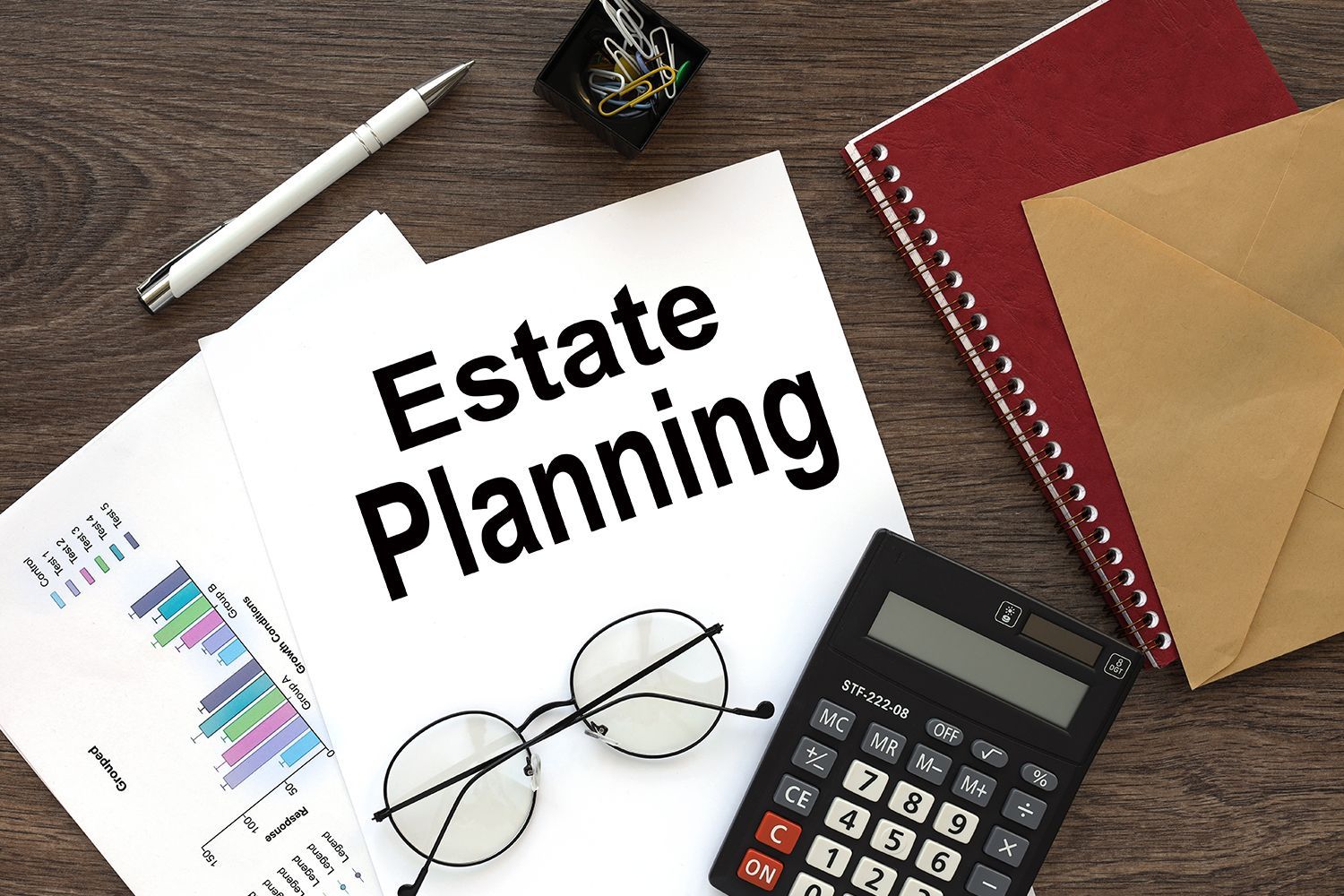 Estate planning document on desk with calculator, pen, glasses, and notebook.